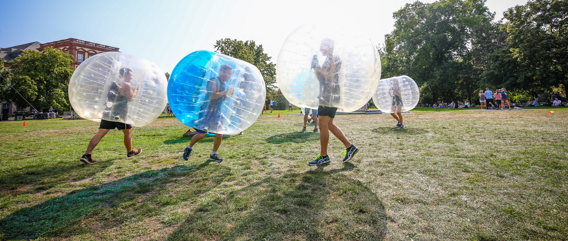 Sportler spielen Bubble-Fußball auf einer Wiese