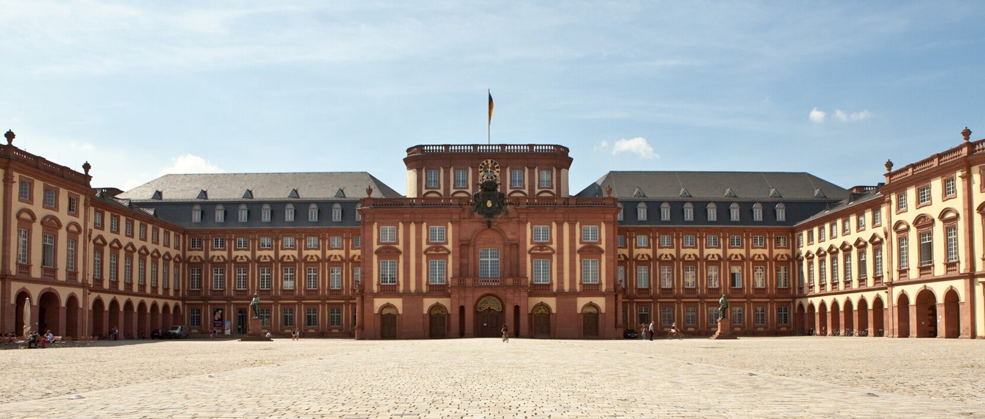 Das Mannheimer Barockschloss und der Ehrenhof bei blauem Himmel.