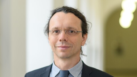 Der Mannheimer Professor Dirk Ifenthaler trägt eine randlose Brille, einen Anzug und blickt freundlich in die Kamera.