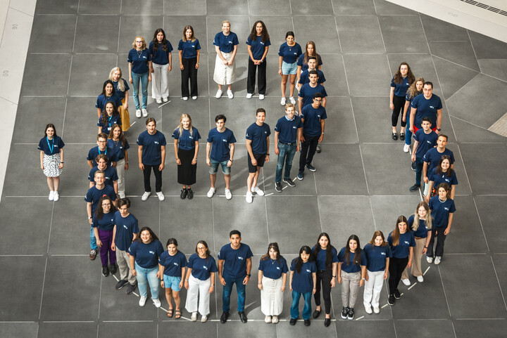 Um die 40 Studierende mit blauem T-Shirt bilden den Buchstaben e. Das Ende des e ist so geformt, dass es auch als u gelesen werden kann, also als "eu". Link: Europäische Universität ENGAGE.EU