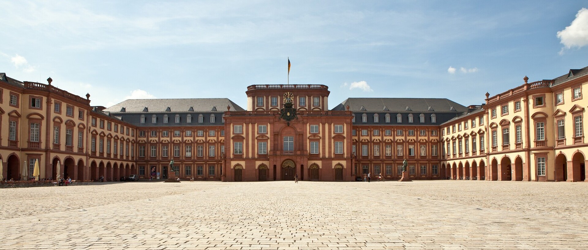 Das Mannheimer Barockschloss und der Ehrenhof bei blauem Himmel.