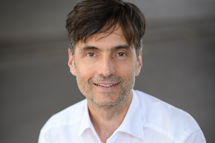 Der Mannheimer Professor Georg W. Alpers trägt ein weißes Hemd und lächelt in die Kamera. Link: Interview mit Professor Alpers.