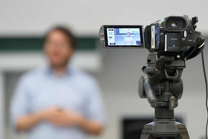 Eine Kamera mit Display bei der Aufnahme einer Person.