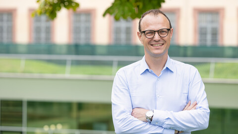 Porträtbild von Professor Moritz Kuhn. Er trägt ein Hemd und eine Brille.