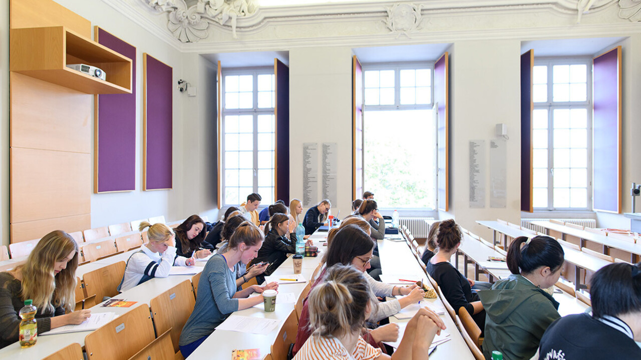 Studierende sitzen in einem kleinen Hörsaal.