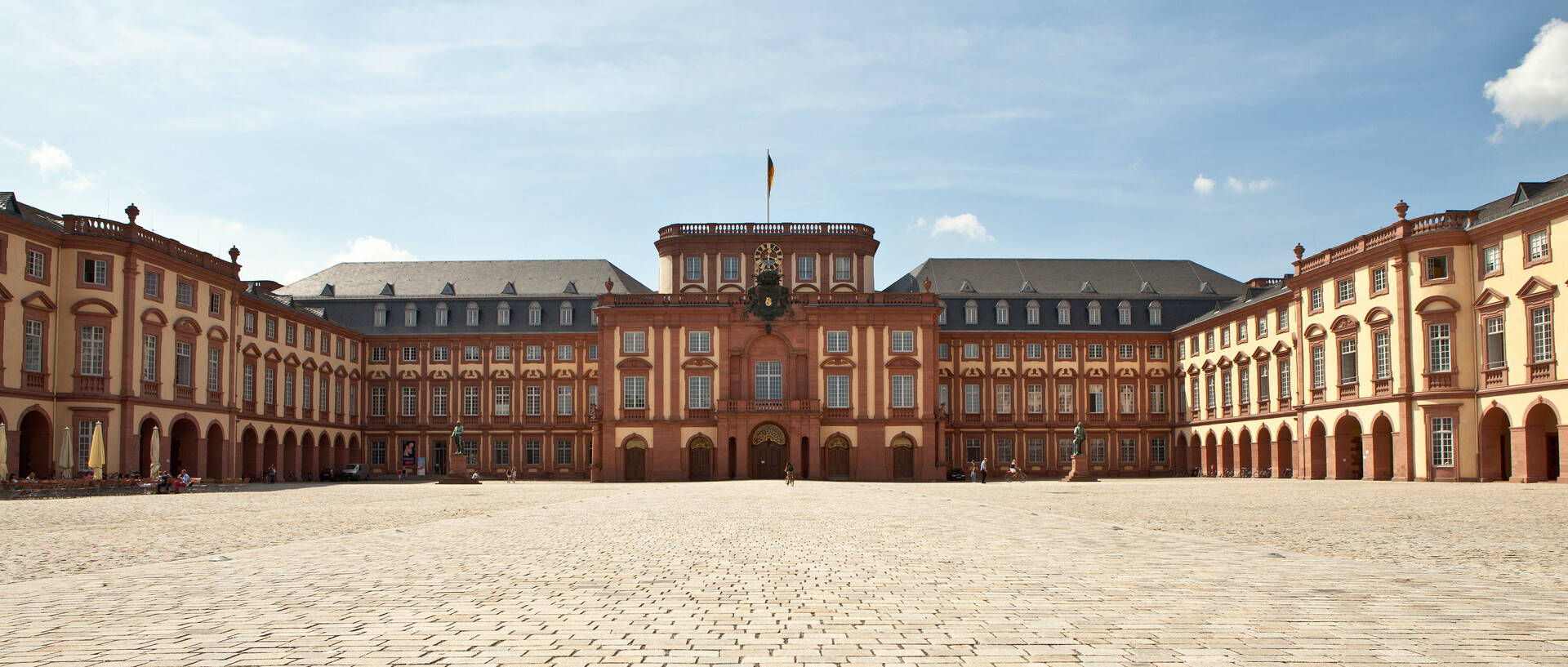 Das Mannheimer Barockschloss und der Ehrenhof unter blauem Himmel.