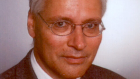 Porträtbild von Professor Ulrich Schreiber. Er trägt einen Anzug und eine Brille.