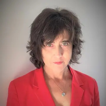 Irena Kogan hat kurze, dunkle Haare und trägt einen roten Blazer. 