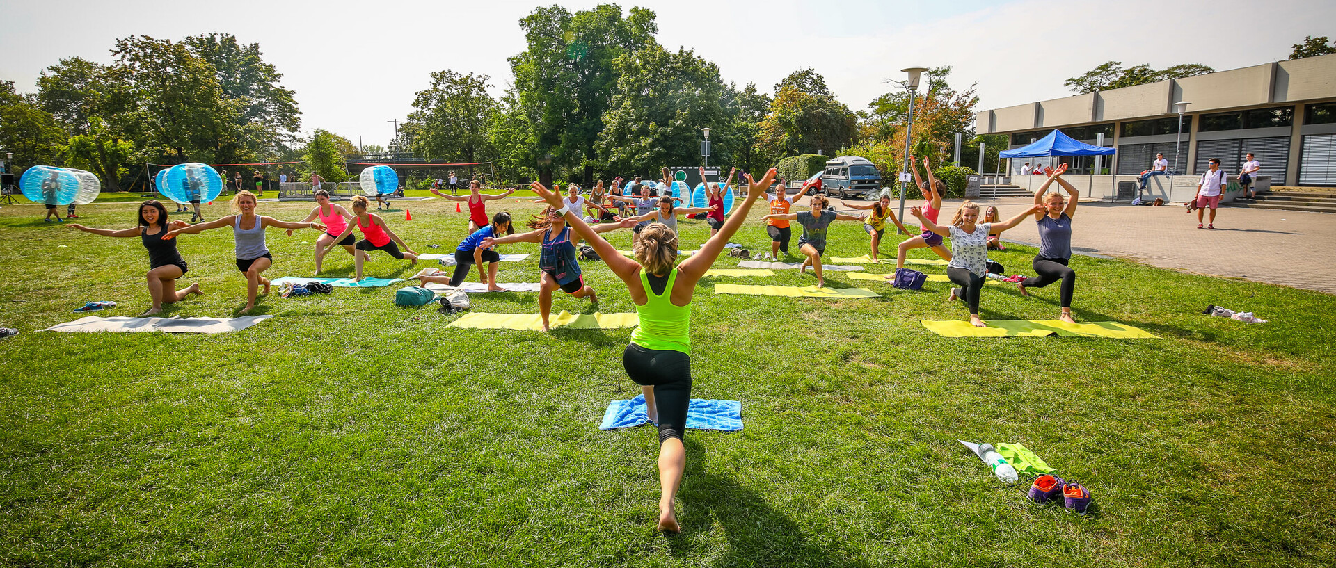 Studierende beim Yogakurs auf der Mensawiese im Sommer