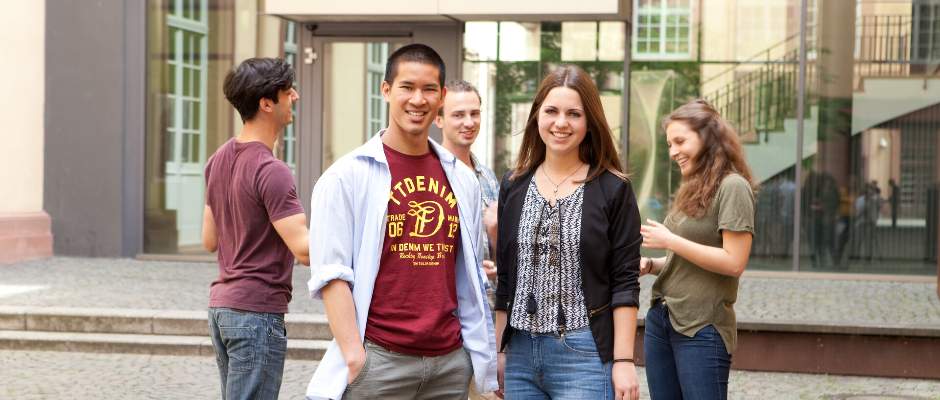 Studierende fröhlich vor der Universität Mannheim