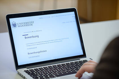 Ein Laptop zeigt die Schritte zur Bewerbung für ein Studium an.