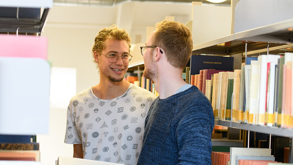 Studierende unterhalten sich in der Bibliothek