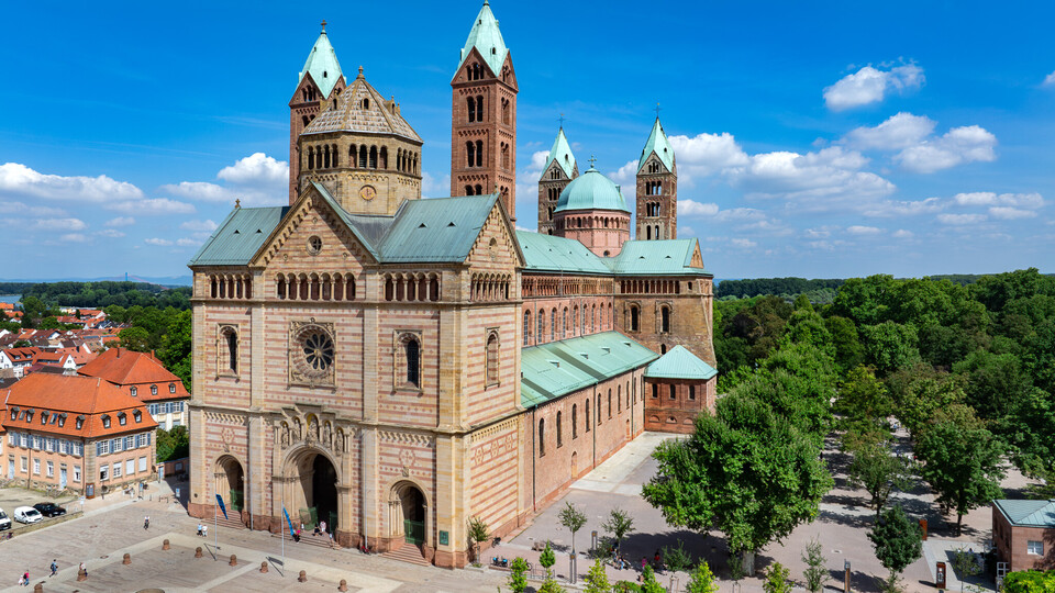 Bild des Doms zu Speyer, es ist ein sonniger Tag, der Himmel ist blau.
