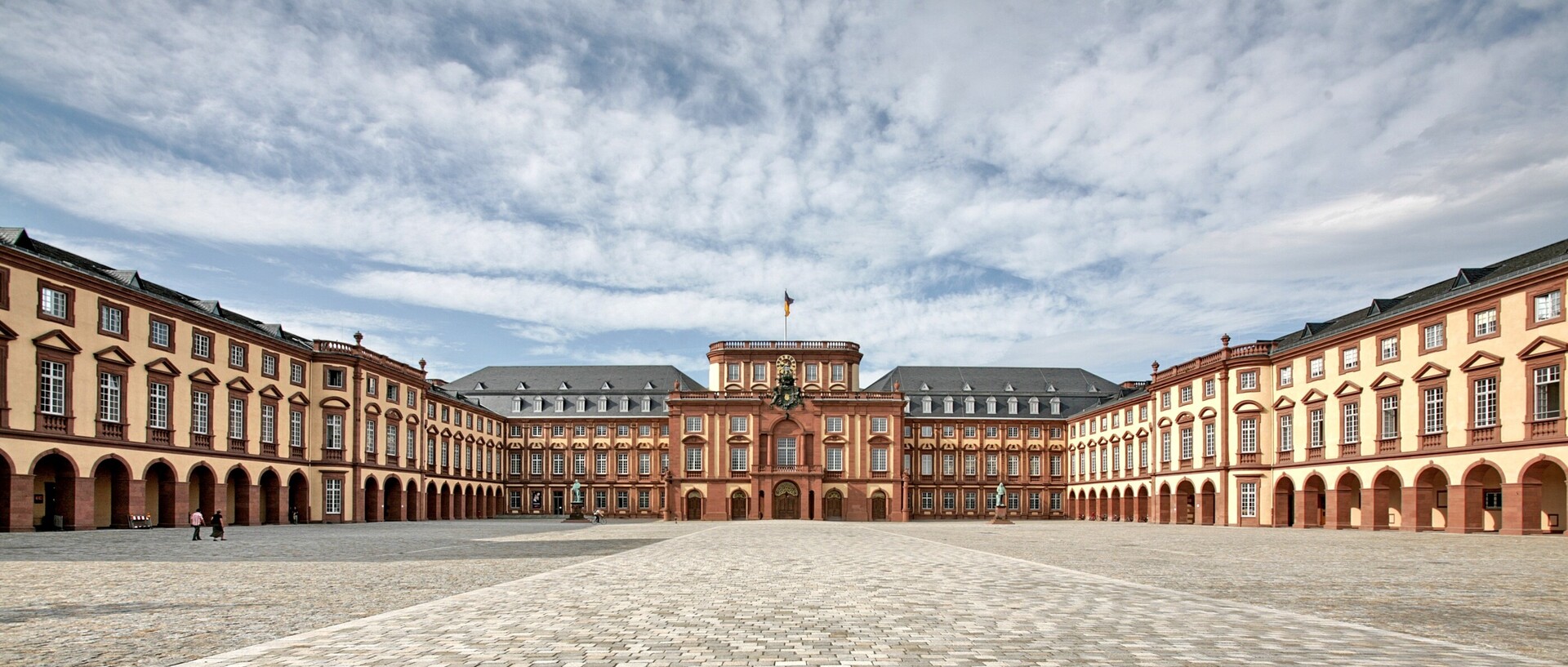 Universität Mannheim mit Ehrenhof an einem leicht bewölkten Tag.