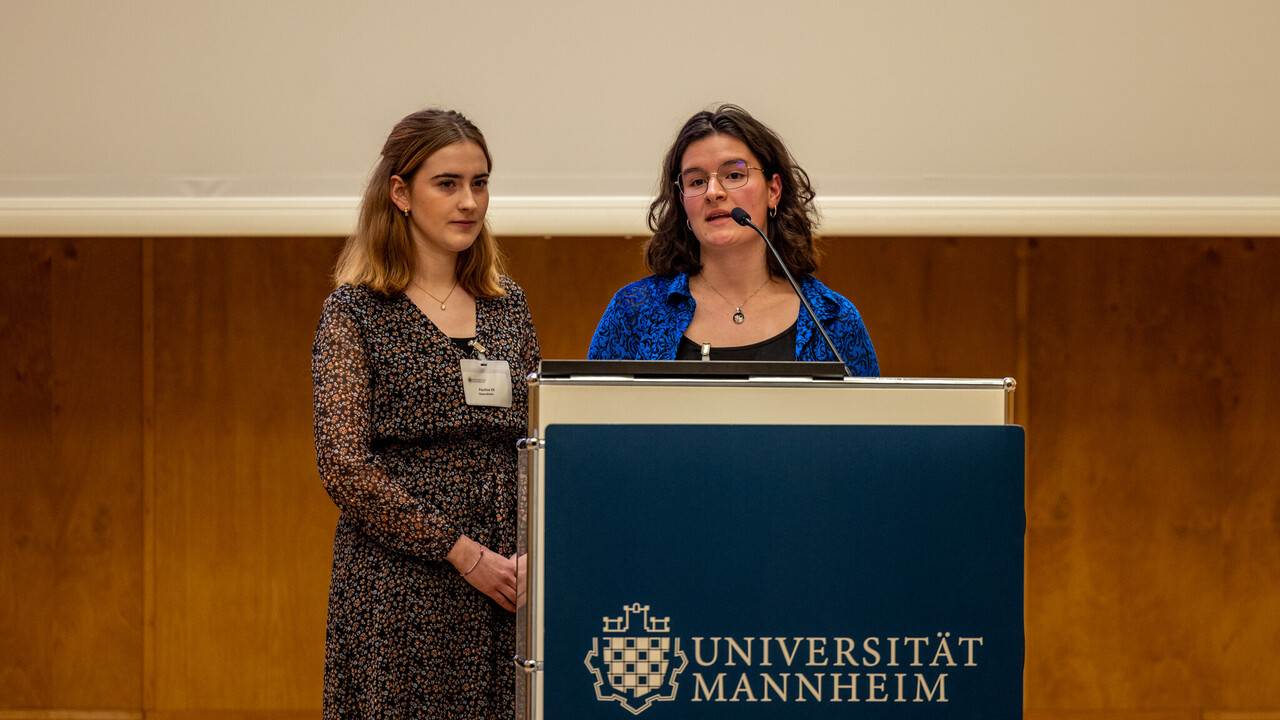 Zwei Personen stehen an einem Rednerpult und sprechen