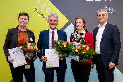 Theresa Bührle, Leonie Fischer, Christoph Spengel and another man are holding certificates and flowers.