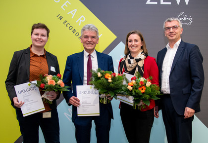 Theresa Bührle, Leonie Fischer, Christoph Spengel and another man are holding certificates and flowers.