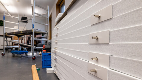 Das Bild zeigt in Großaufnahme Details von schallhemmenden Lammellen für die Raumdecke