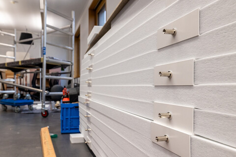 Das Bild zeigt in Großaufnahme Details von schallhemmenden Lammellen für die Raumdecke