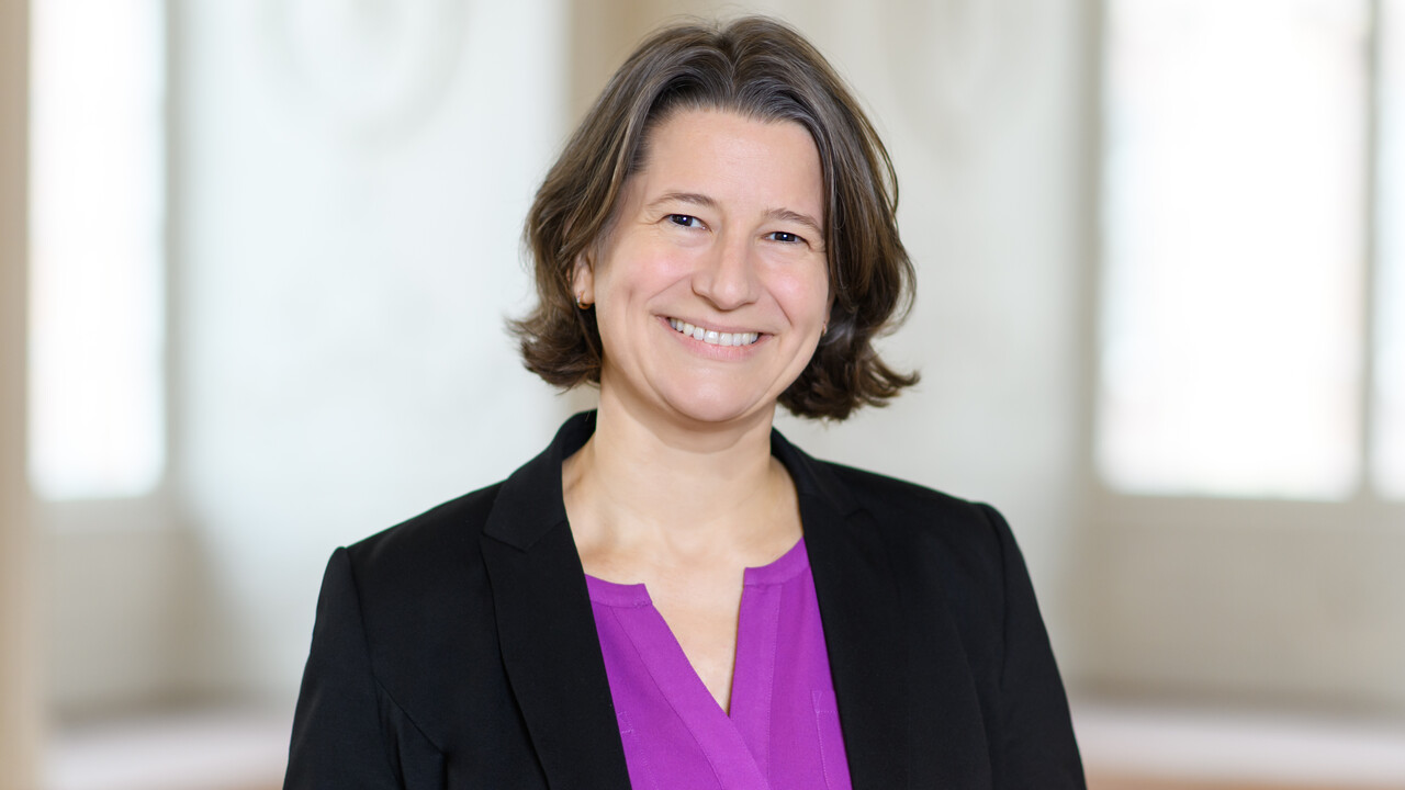 Kanzlerin Dr. Katrin Schoppa-Bauer Katrin Schoppa trägt ein dunkles Jacket und eine lila Bluse.