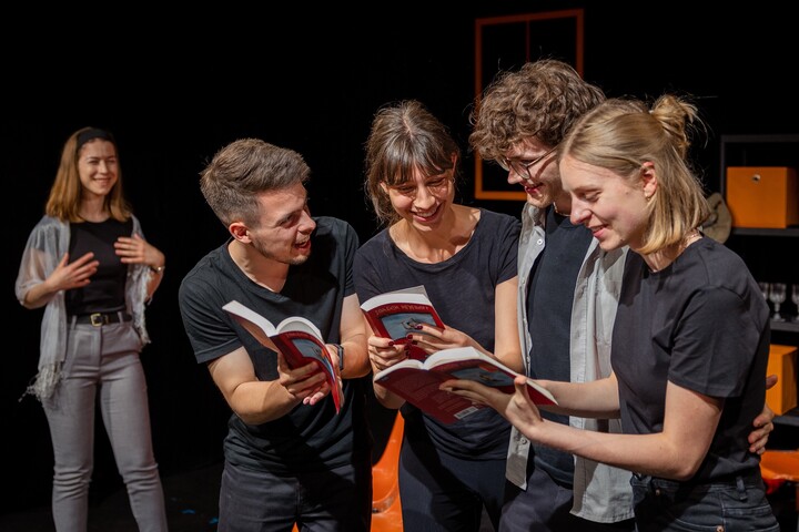 Theaterspielende lesen in Büchern.