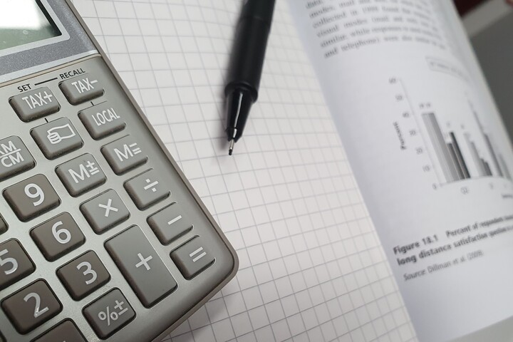 Calculator and pen lying on a statistics book.