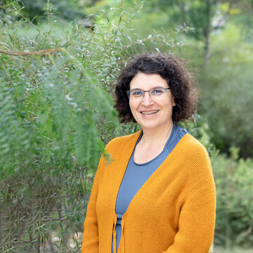  Christiane Feldhaus. Christiane Feldhaus trägt einen gelben Cardigan und lächelt.