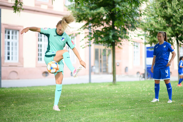Zwei Frauen spielen Fußball.
