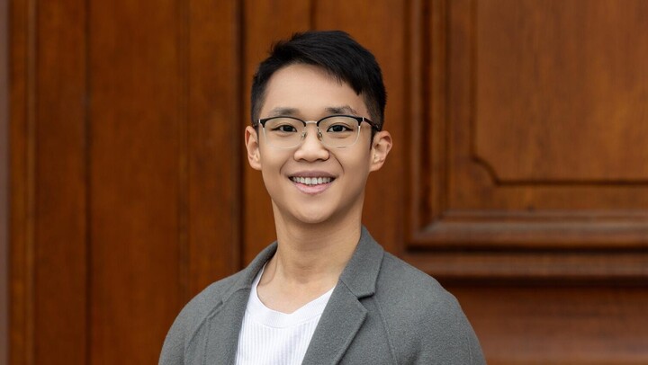 Weiqing Tong. He ist wearing a white shirt and a beige jacket.