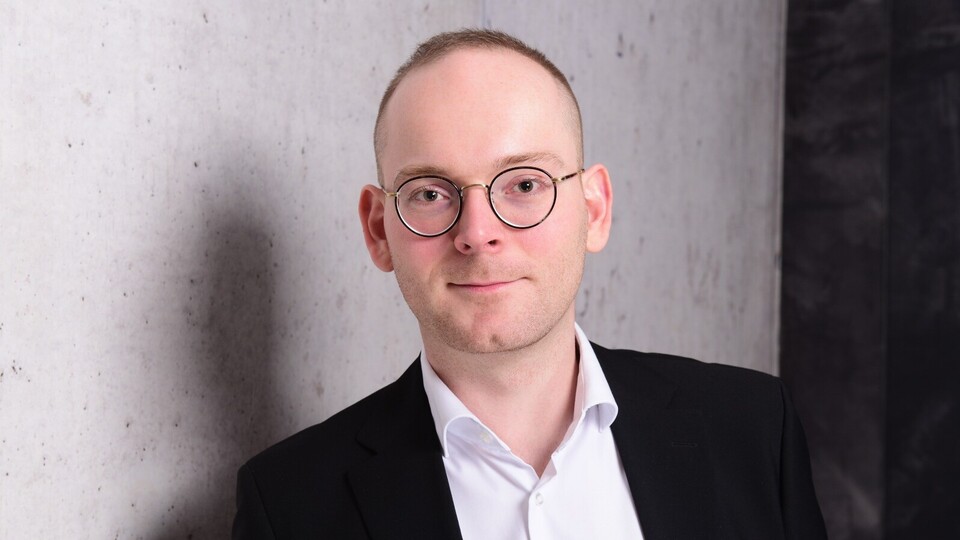 Portraitfoto von Dr. Constantin Wurthmann. Er trägt ein weißes Hemd und ein schwarzes Sakko.