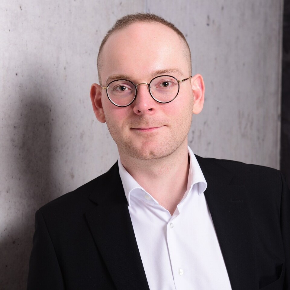 Portraitfoto von Dr. Constantin Wurthmann. Er trägt ein weißes Hemd und ein schwarzes Sakko.