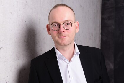 Portraitfoto von Dr. Constantin Wurthmann. Er trägt ein weißes Hemd und ein schwarzes Sakko.