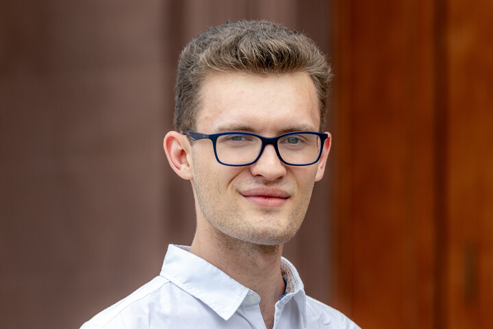 Marc Hattermann. Die Person trägt Brille, ein weißes Hemd und lächelt in die Kamera