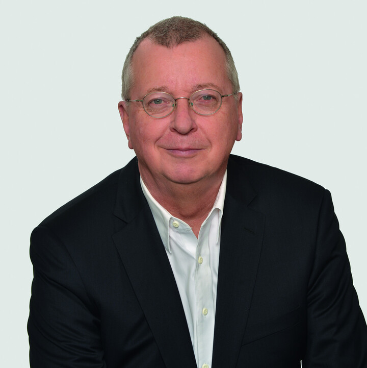 Prof. Dr. Dr. h. c. Martin Weber mit kurzen hellbraunen Haaren, einer runden goldenen Brille und schwarzem Anzug im Porträt vor einer weißen Wand