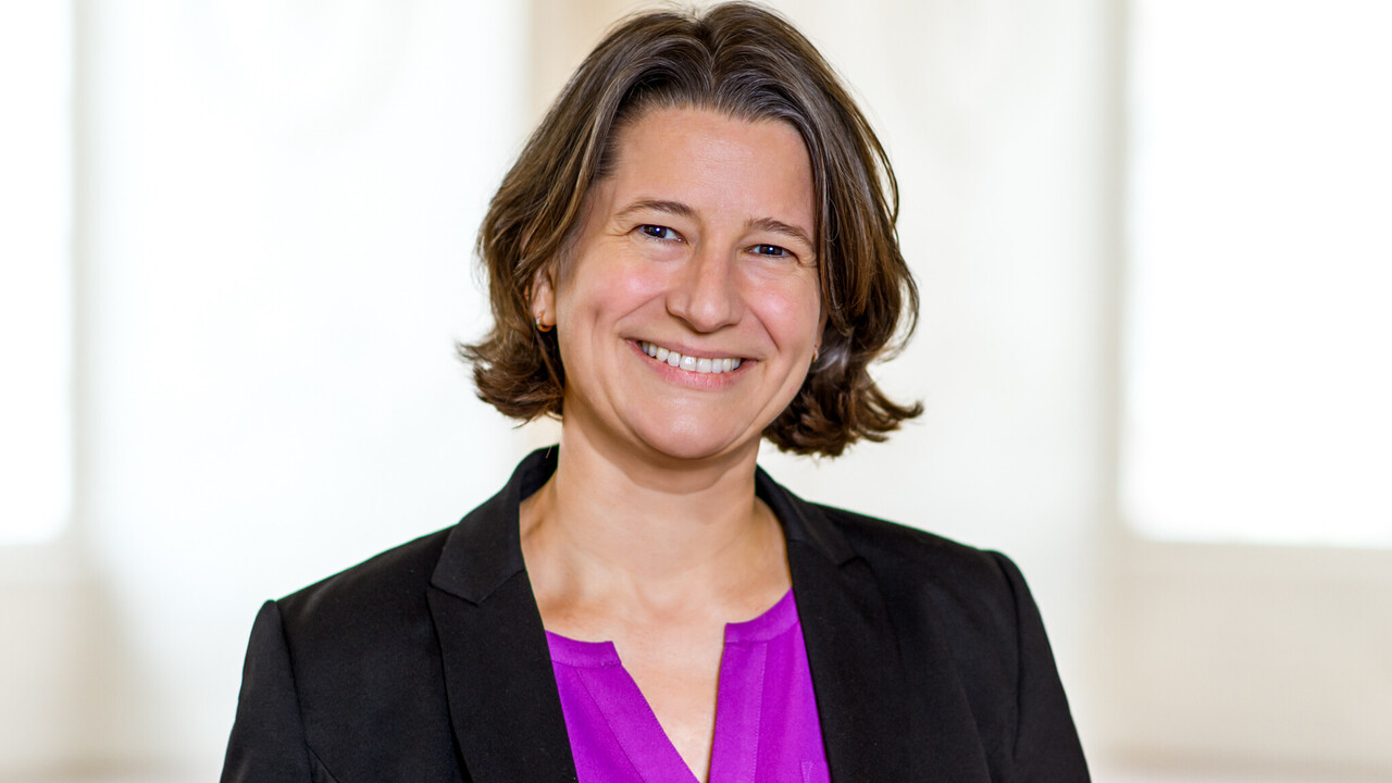 Executive Vice President Dr. Katrin Schoppa-Bauer Dr. Katrin Schoppa-Bauer hat braune mittellange Haare. Sie trägt einen schwarzen Blazer und eine lilafarbene Bluse.