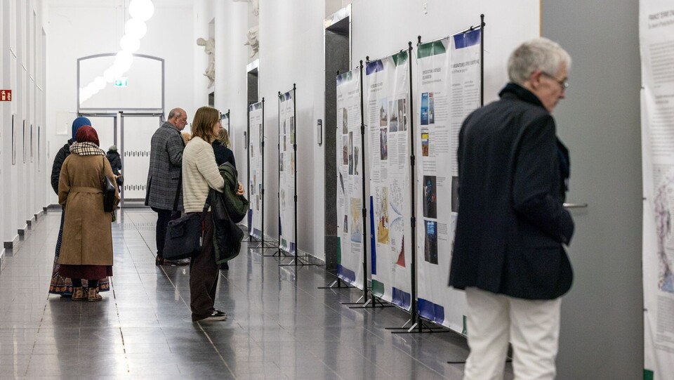 Menschen stehen im Ausstellungsflur und schauen sich die Präsentation an.