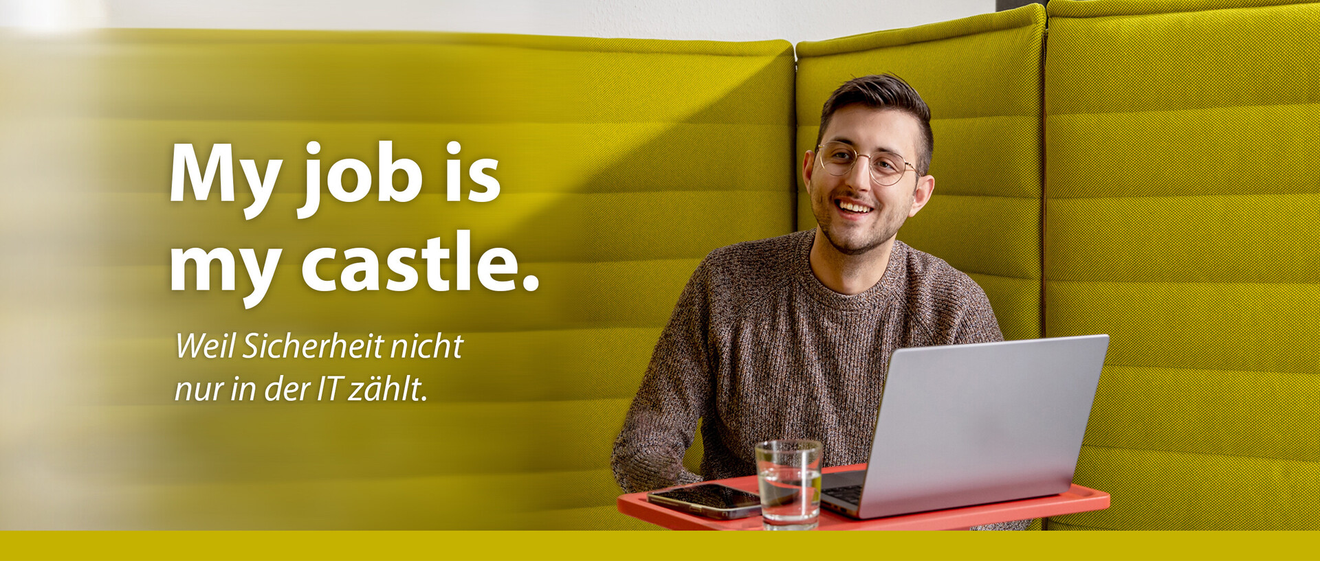Ein Mitarbeitender arbeitet an seinem Laptop in einer Sitzecke