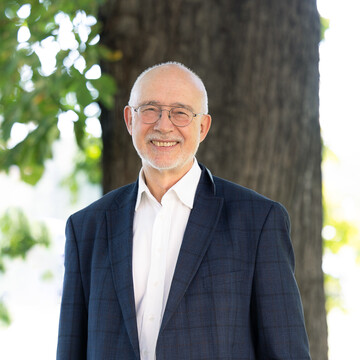  Prof. Dr. Thomas Puhl. Er lächelt freundlich, trägt eine Brille und ein dunkelblaues Jackett. 