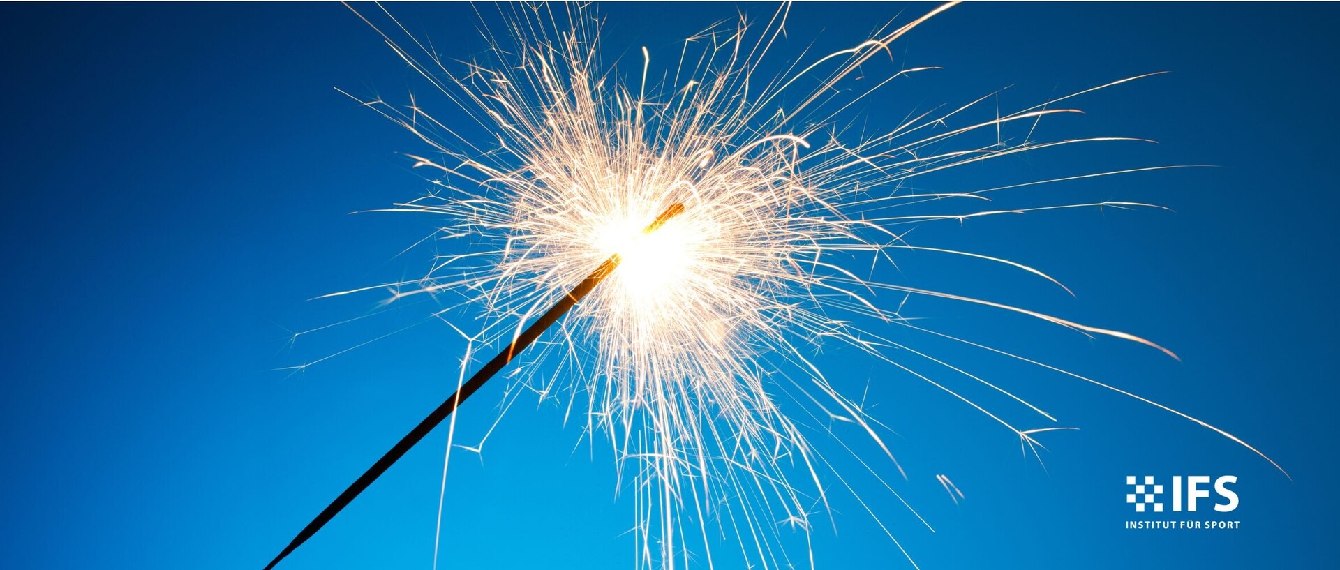 Brennende Wunderkerze vor blauem Hintergrund