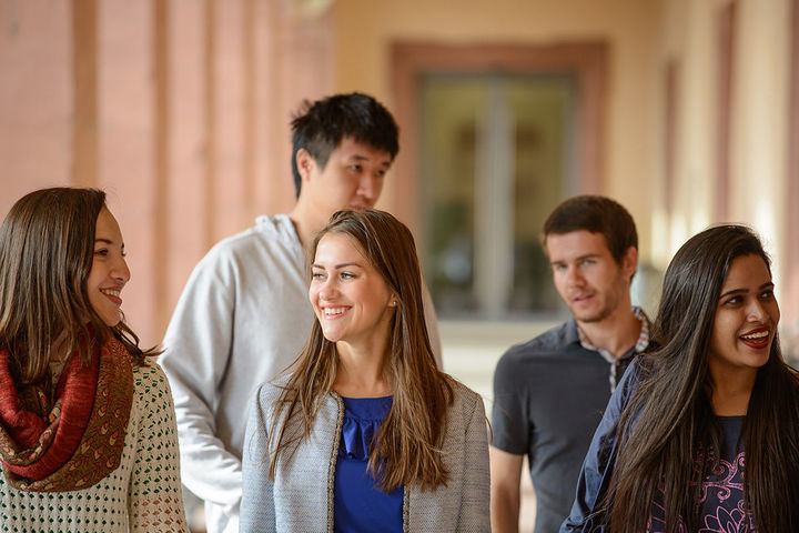 Fünf internationale Studierende stehen unter den Schlossarkaden.