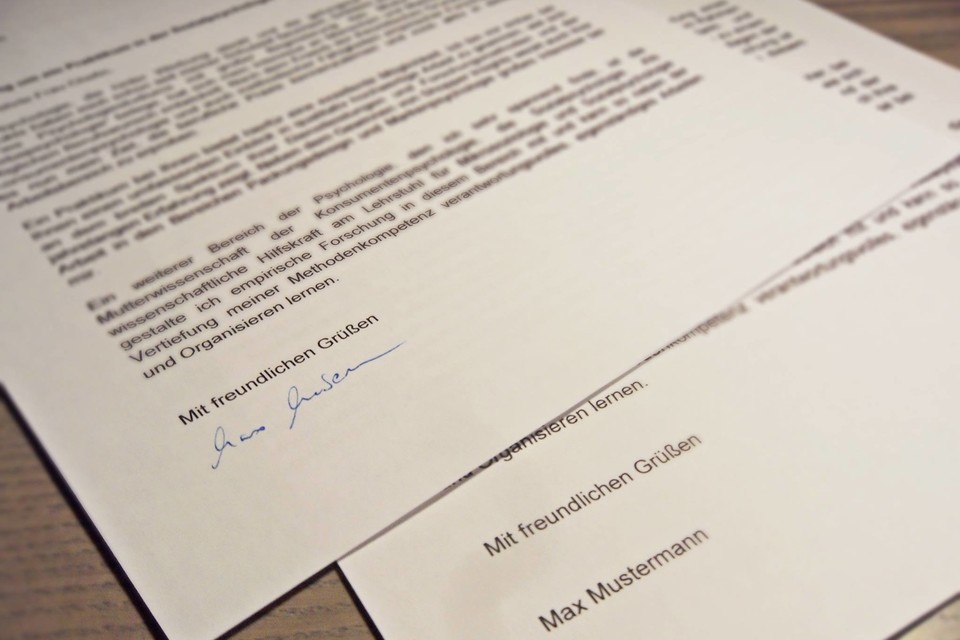 Zwei maschinell erstellte Schreiben liegen auf einem Tisch, eins wurde händisch unterschrieben.