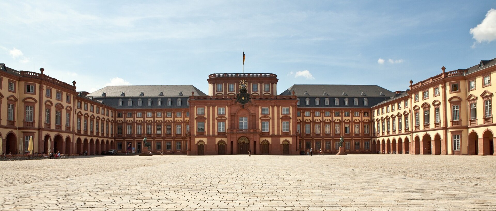 Das Mannheimer Barockschloss und der Ehrenhof bei blauem Himmel.