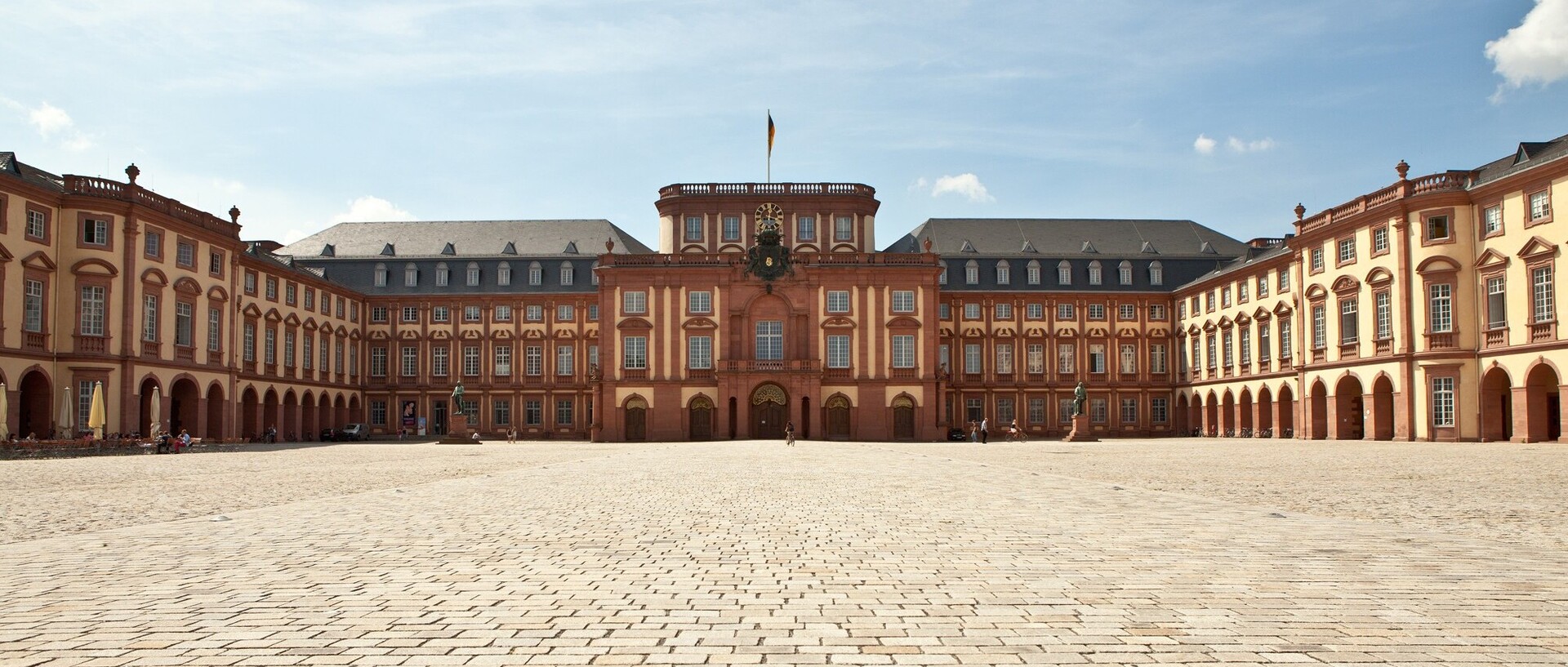 Das Mannheimer Barockschloss und der Ehrenhof bei blauem Himmel.