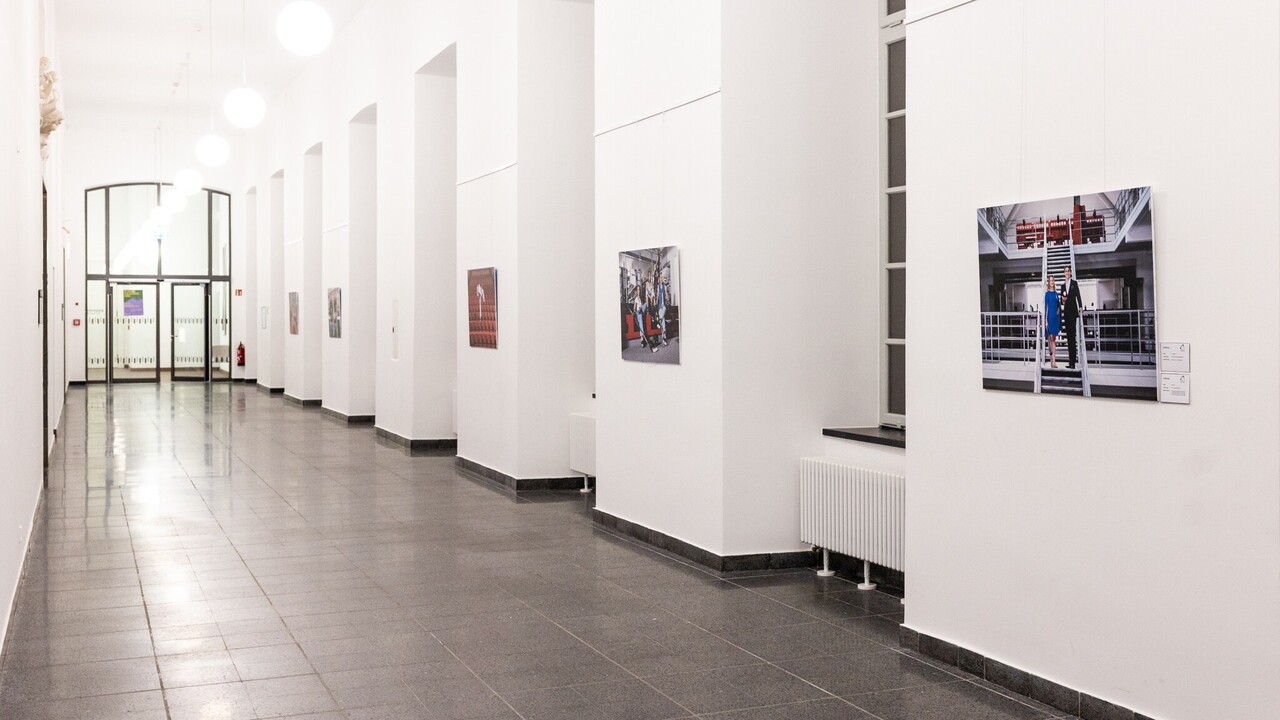 In einem Flur hängen Bilder an der Wand.