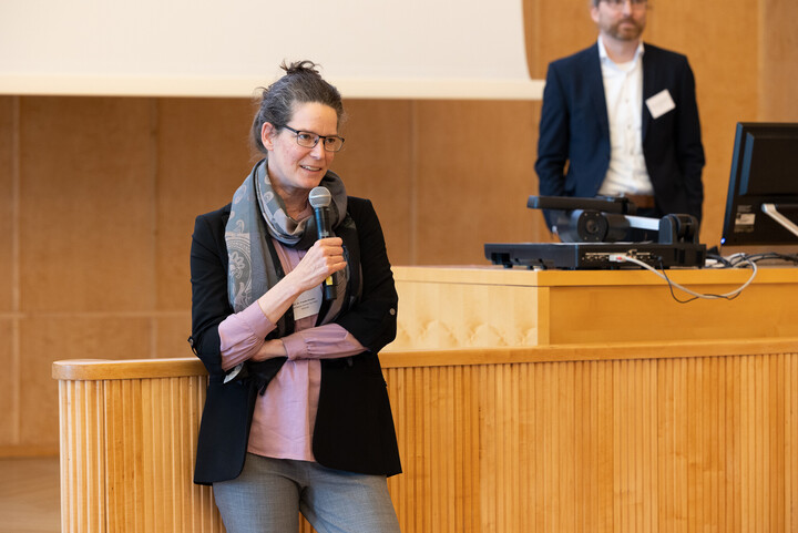 Prof. Dr. Frauke Kreuter auf der Bühne der Aula. Sie trägt formelle Kleidung und hält ein Mikrofon. 