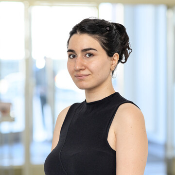 Elene Rakviashvili hat schwarze, zu einem Zopf gebundene Haare. Sie trägt ein schwarzes Oberteil.