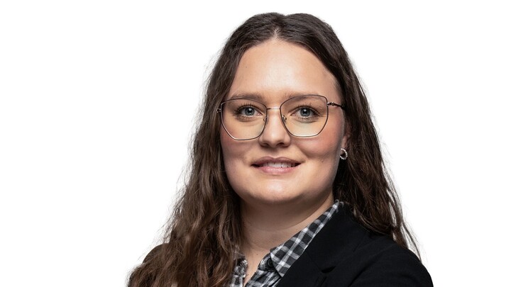 Lynn-Malou Lutz wearing glasses, checkered shirt, dark jacket