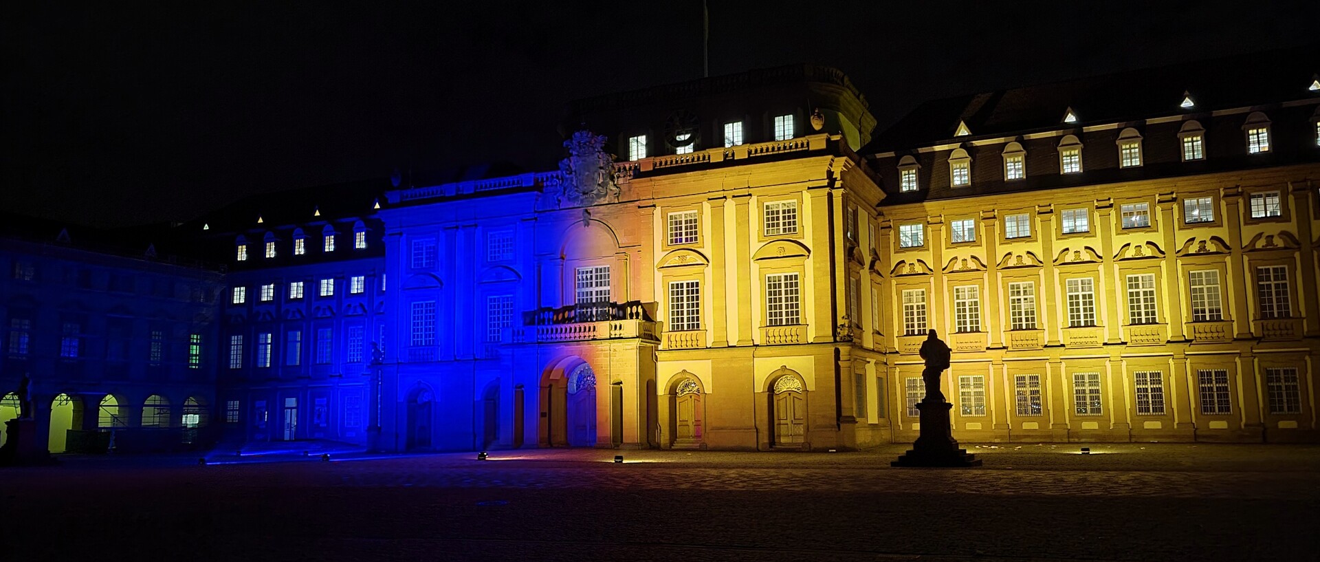 Das Mannheimer Barockschloss wird in blau und gelb angeleuchtet.