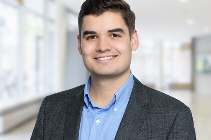 Arthur Seibold trägt ein hellblaues Hemd, sowie einen grauen Blazer und lächelt.