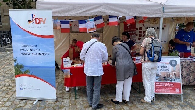 Besuchergruppe vor dem Stand der Deutsch-Französischen Vereinigung und des Romanischen Seminars beim Bal Populaire.